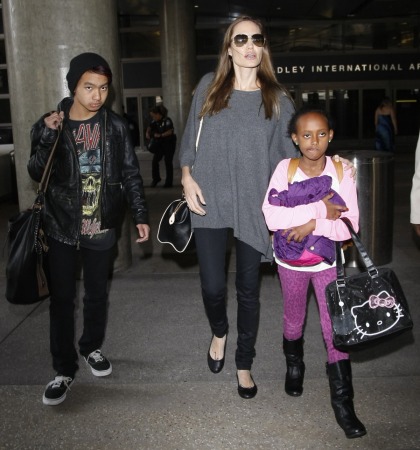 Angelina Jolie wore an oversized sack-poncho at LAX with Zahara & Maddox